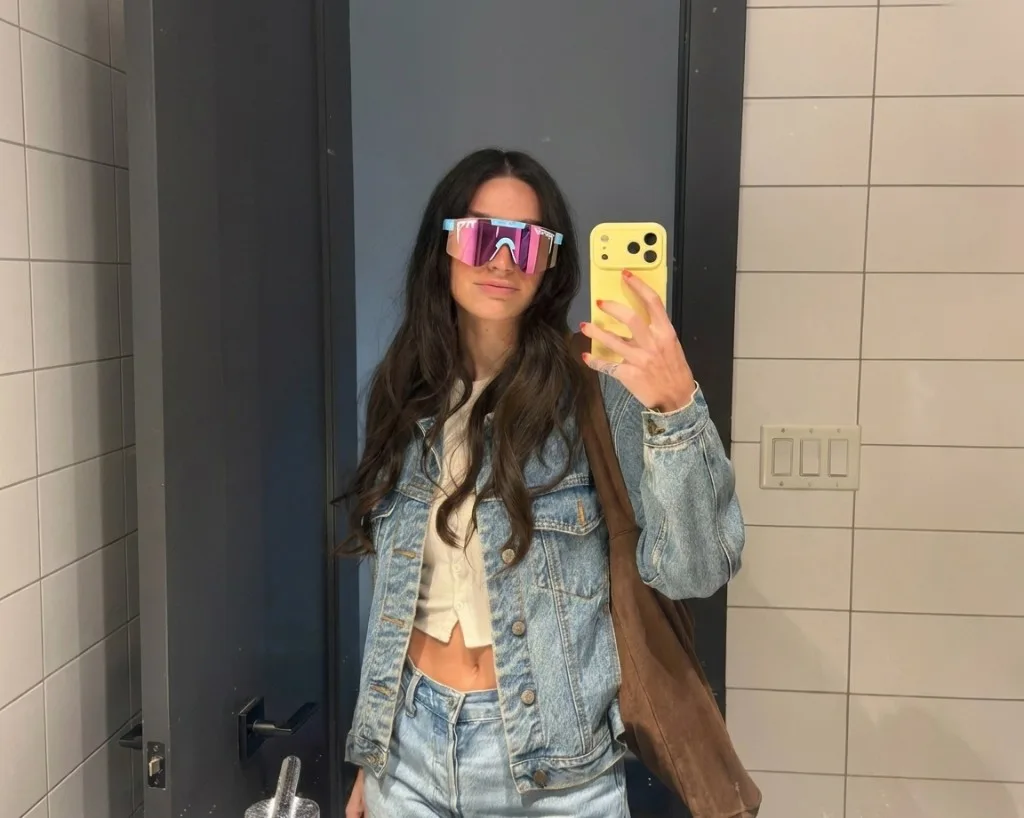Woman taking a mirror selfie wearing Jetski Pit Vipers (light blue frame, pink lens)